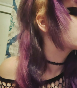 Close up of punk hairstyle, side shave, un-dyed, purple dye shades, fishnet, thick wing eye liner.