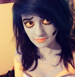 A close up of corpse bride makeup, blue skin, blue hair