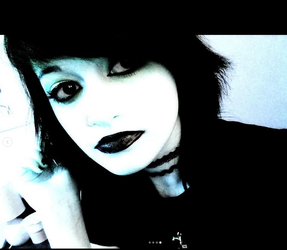 A close up of Trinity Coblentz with a high contrast filter, black lipstick, black eyeliner, choker.